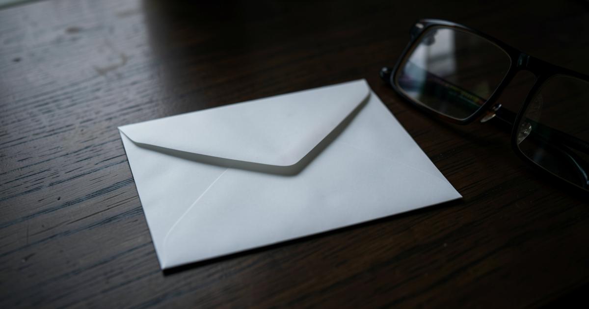 Verschlossener Briefumschlag auf einem Holztisch