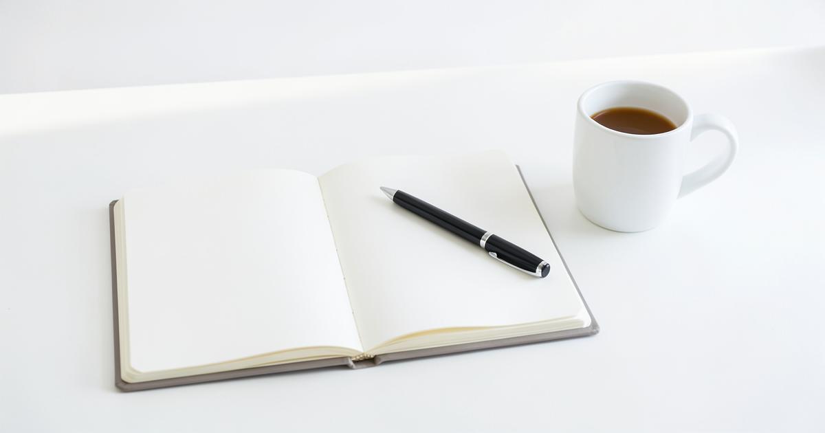 Notizbuch, Stift und Smartphone auf einem hellen Tisch